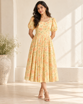 Adult Indian woman modeling the calf-length pastel-yellow floral cotton dress, front view